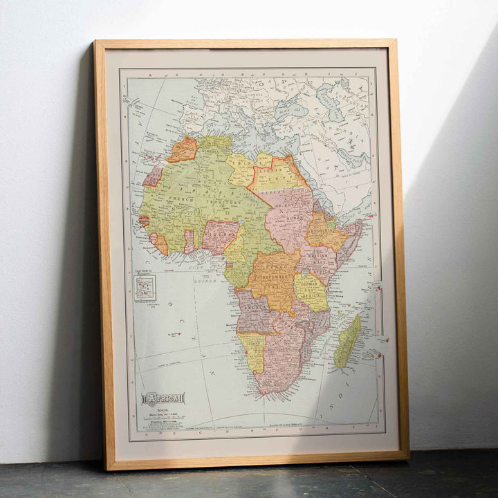 Rand McNally and Company Africa Map vintage poster of the African continent in muted green yellow pink and beige tones, with wooden magnetic frame on white background