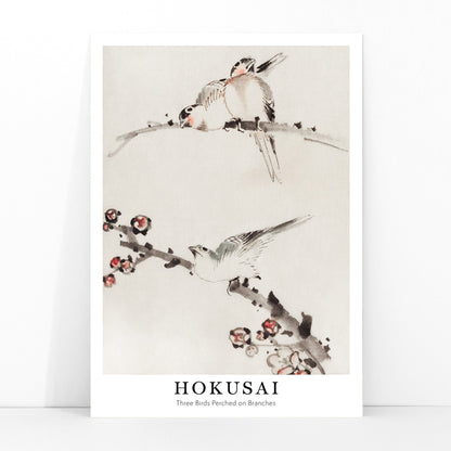 Three birds perched on branches with blossoms watercolor painting and poster artwork by Katsushika Hokusai, framed and displayed in modern living room decor