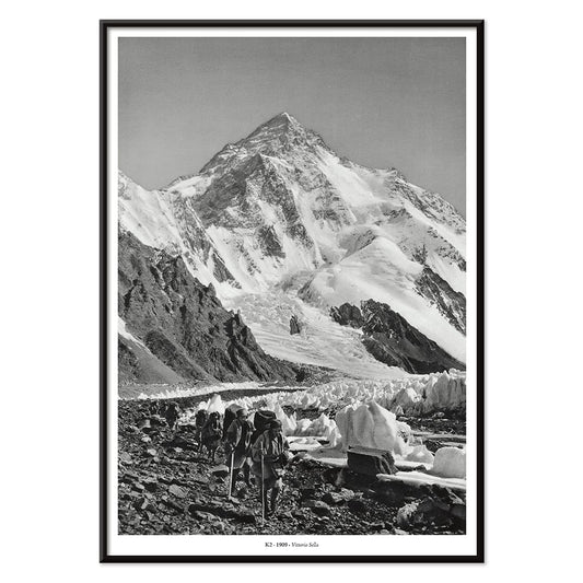 Black and white photo by Vittorio Sella of mountaineers trekking toward K2 over the Godwin Austen glacier titled Le pic K2 vue prise du glacier Godwin Austen, with black aluminium frame on white background