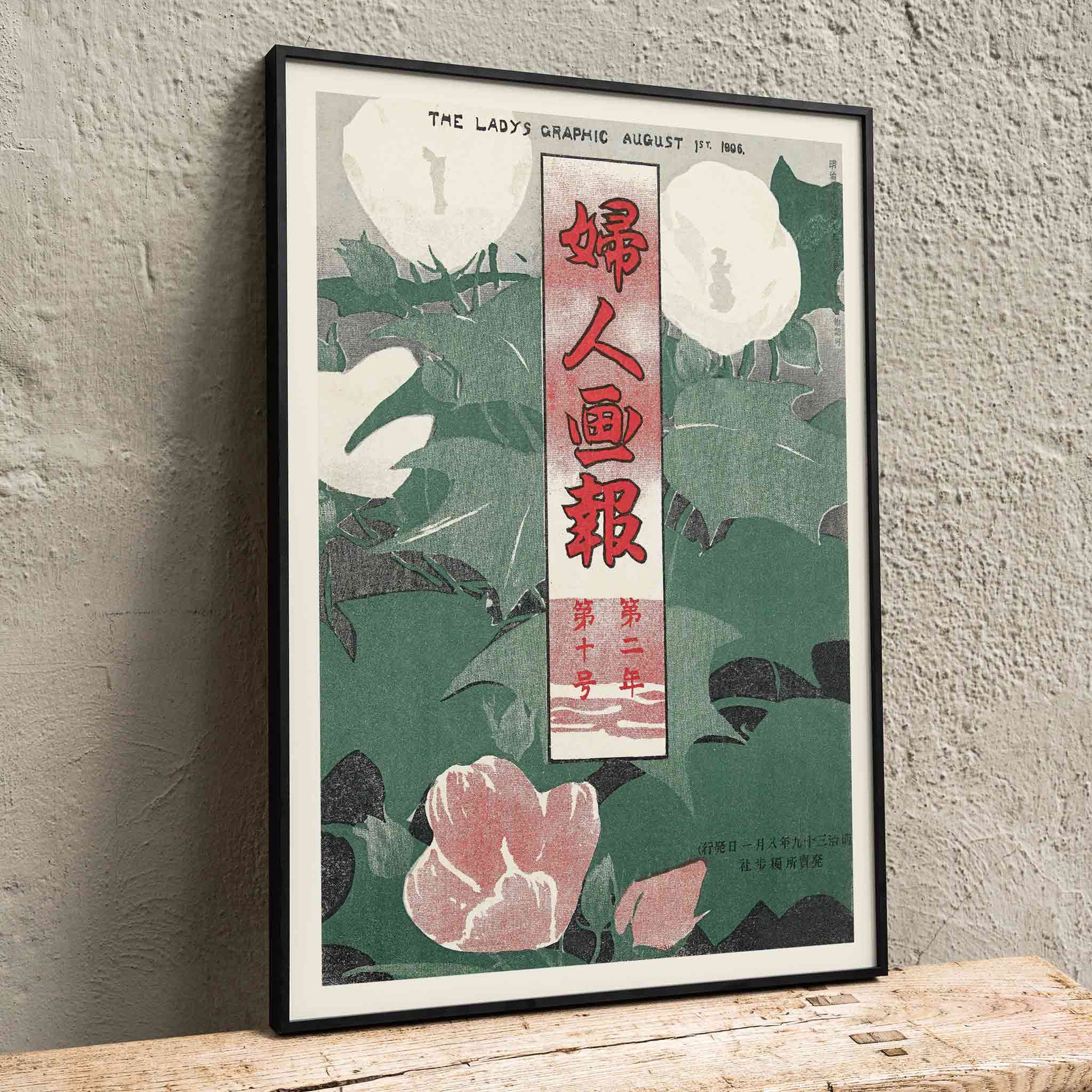 The Lady Graphic by Mitsutani Kunishiro poster with white flowers, green leaves, red lettering, and botanical foliage, framed and displayed in home decor