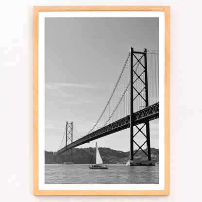Lisbon Bridge Black and White Poster by Raphael Alves featuring a framed photograph of a suspension bridge and sailboat in the water, with black aluminium frame on white background