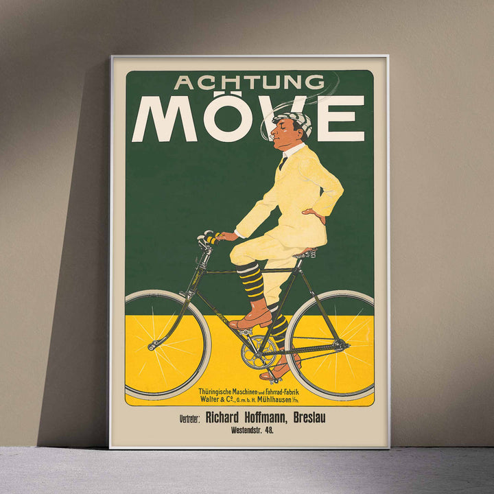 Achtung Moeve poster by J. and Co. Aberle featuring a cream cyclist on a vintage bicycle against a green and yellow cycling scene, with wooden magnetic frame on white background