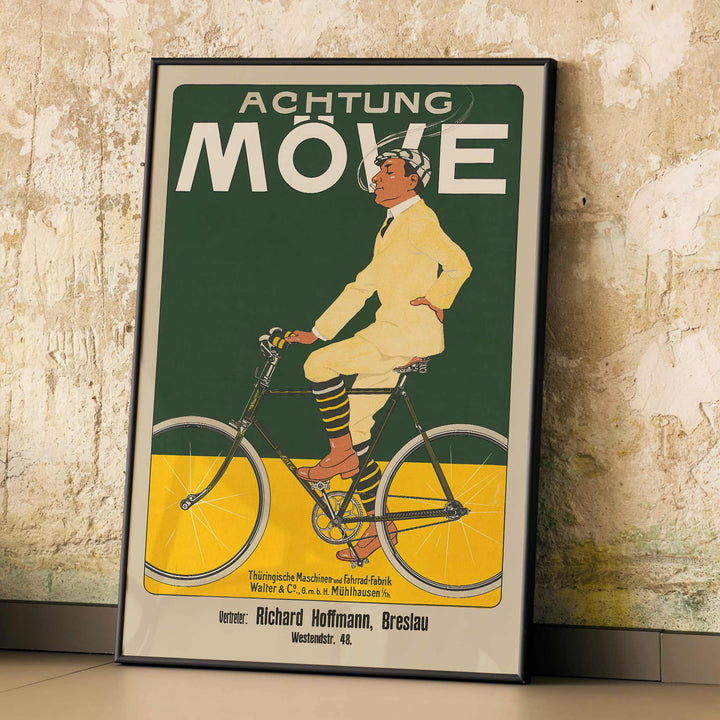 Achtung Moeve poster by J. and Co. Aberle featuring a cream cyclist on a vintage bicycle against a green and yellow cycling scene, framed and displayed in modern living room decor