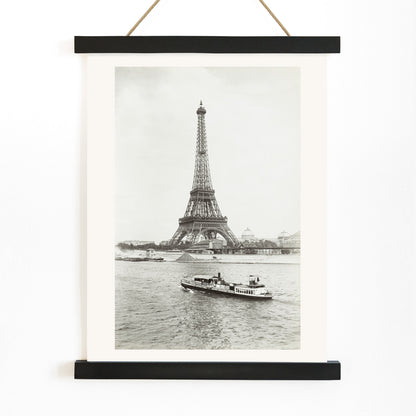 Black and white photograph and poster of the Eiffel Tower in Paris with a vintage boat on the Seine river wall decor artwork, with wooden magnetic frame on white background
