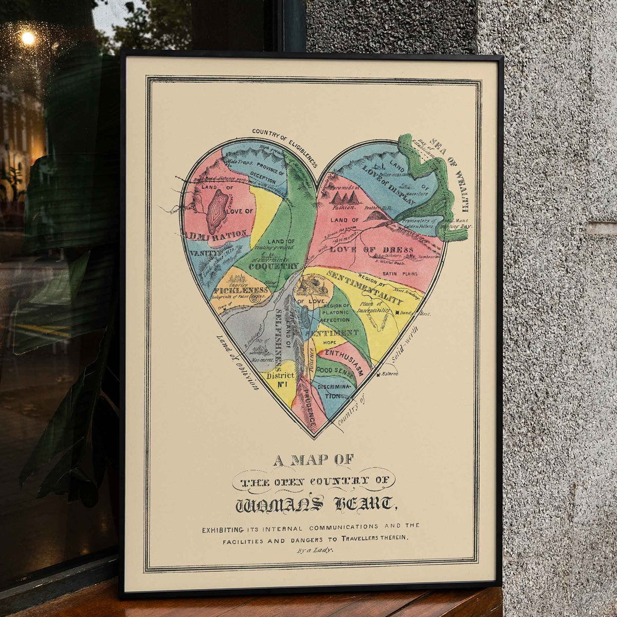Open Country of Womans Heart poster by E.B. and E.C. Kellogg, colorful heart shaped map with labeled regions, vintage cartographic style, framed and displayed in home decor