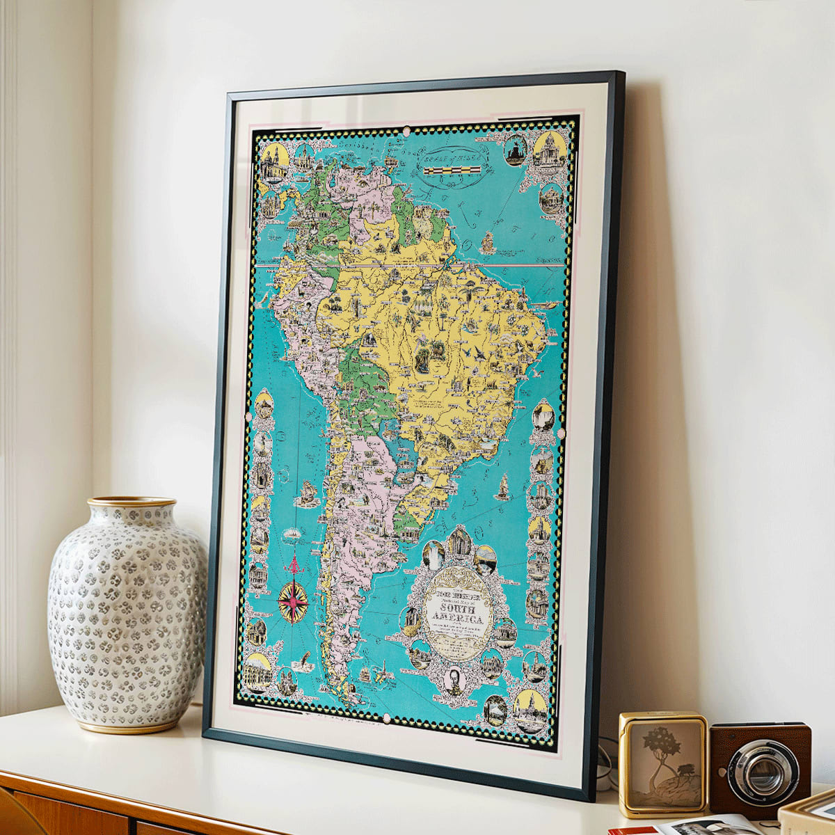 Colorful illustrated map poster of South America by Ernest Dudley Chase titled The Good Neighbor of South America, framed and displayed in modern living room decor