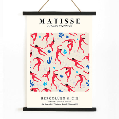 Henri Matisse Dancing Figures Exhibition Poster with vibrant red and blue design featuring red cut out figures on a patterned background with exhibition details, with wooden magnetic frame on white background