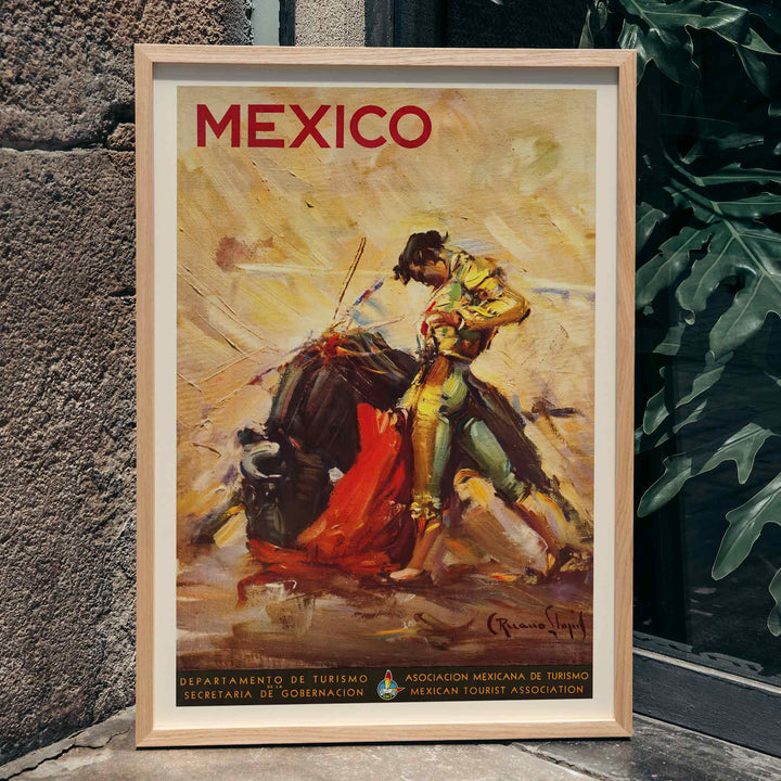 Mexico travel poster by Carlos Ruano Llopis showing a matador facing a bull in a dramatic vintage tourism scene, framed and displayed in home decor