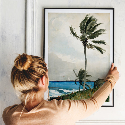 Windy tropical beach with palm trees and ocean by Winslow Homer featuring Palm Tree Nassau and lighthouse in the background, framed and displayed in home decor