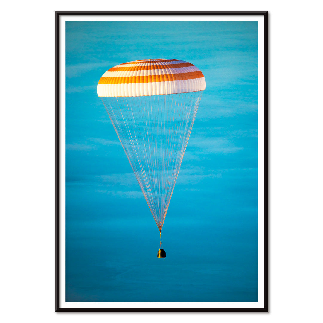 Soyuz TMA-14M spacecraft descending with parachute against blue sky NASA Expedition 42 landing poster artwork, with black aluminium frame on white background