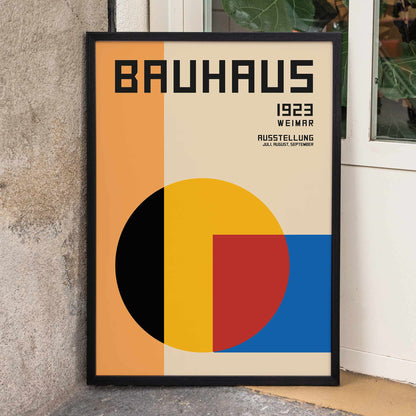 Bauhaus Poster 1 inspired by the Weimar Exhibition featuring geometric shapes in warm bold colors and modernist design style, framed and displayed in home decor