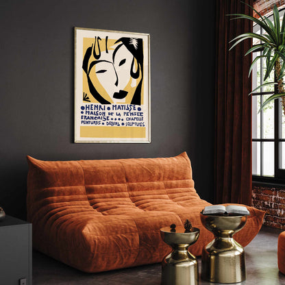 Henri Matisse Maison de la Pensee francaise poster with bold black abstract face shapes on warm yellow and cream minimalist design, framed and displayed in modern living room decor